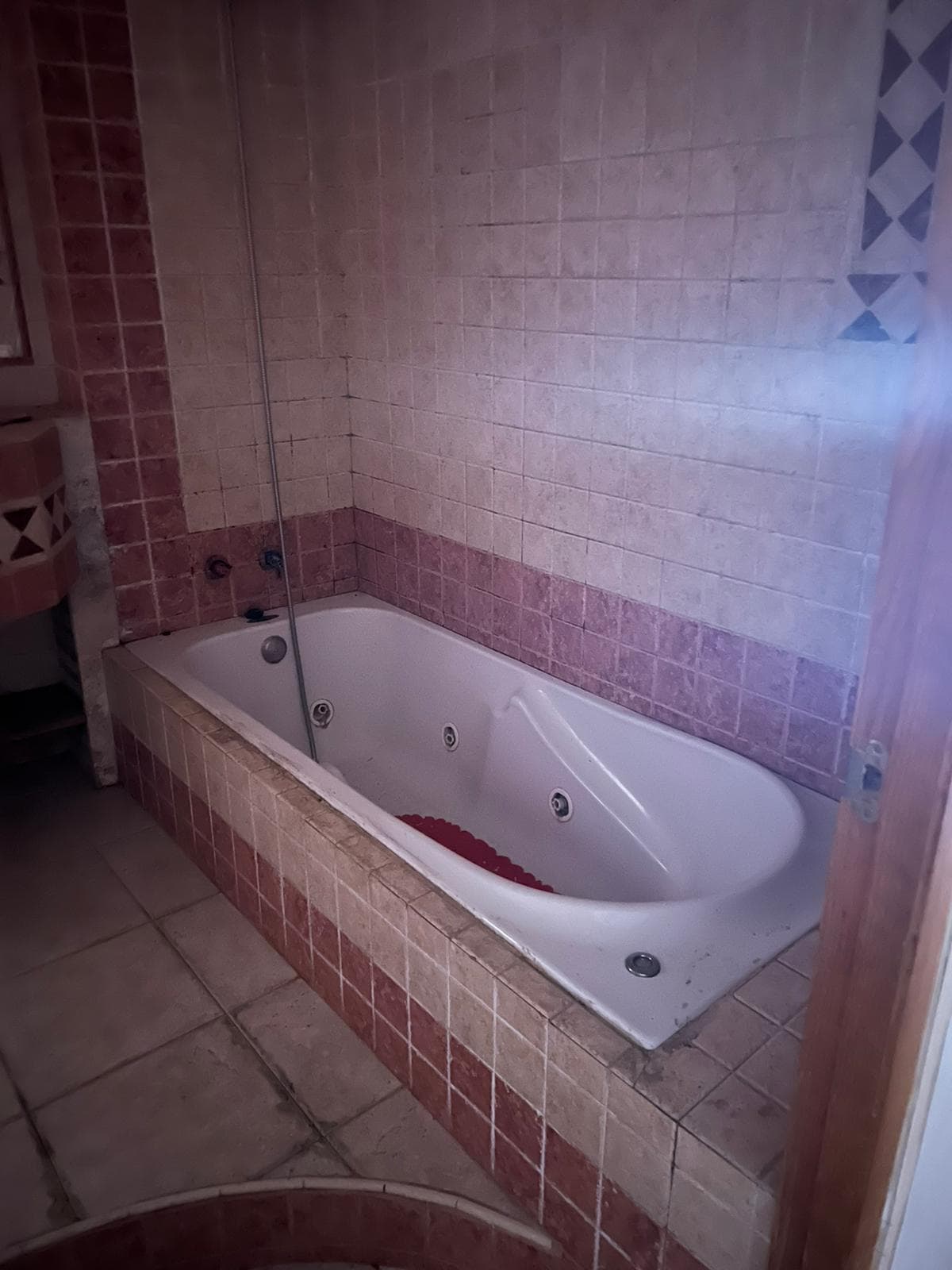 Baño antes de la reforma, con el estado de las paredes y el suelo a la vista